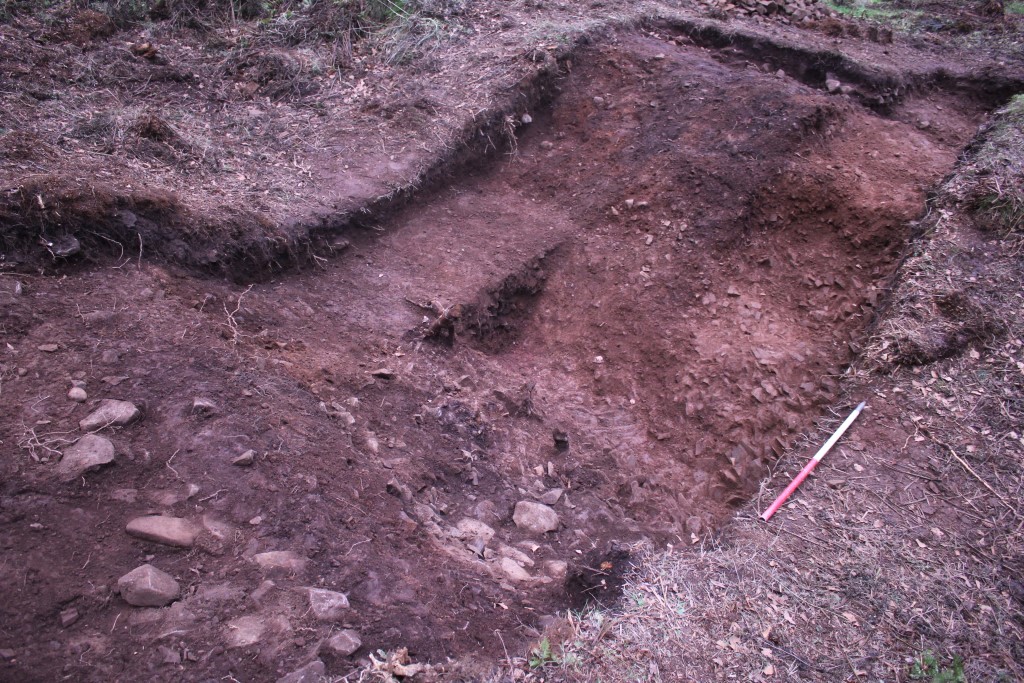 Image of the ditch during excavations, with steeply sloping sides dropping down into a rock-cut ditch