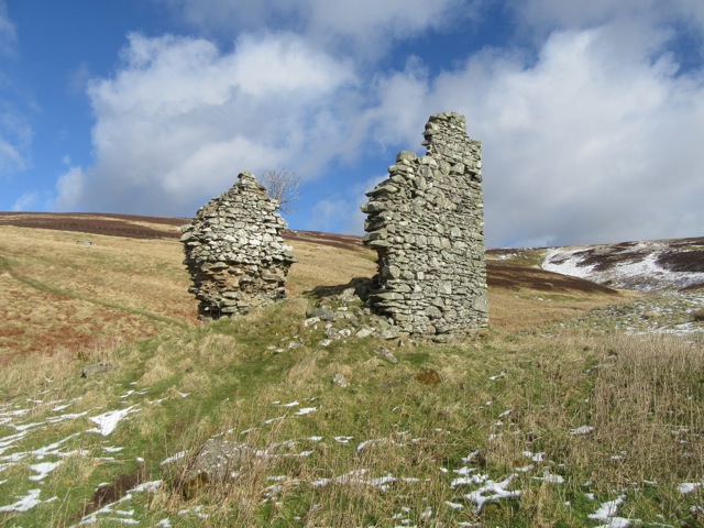 Ruinous remains of castle walls in open landscape