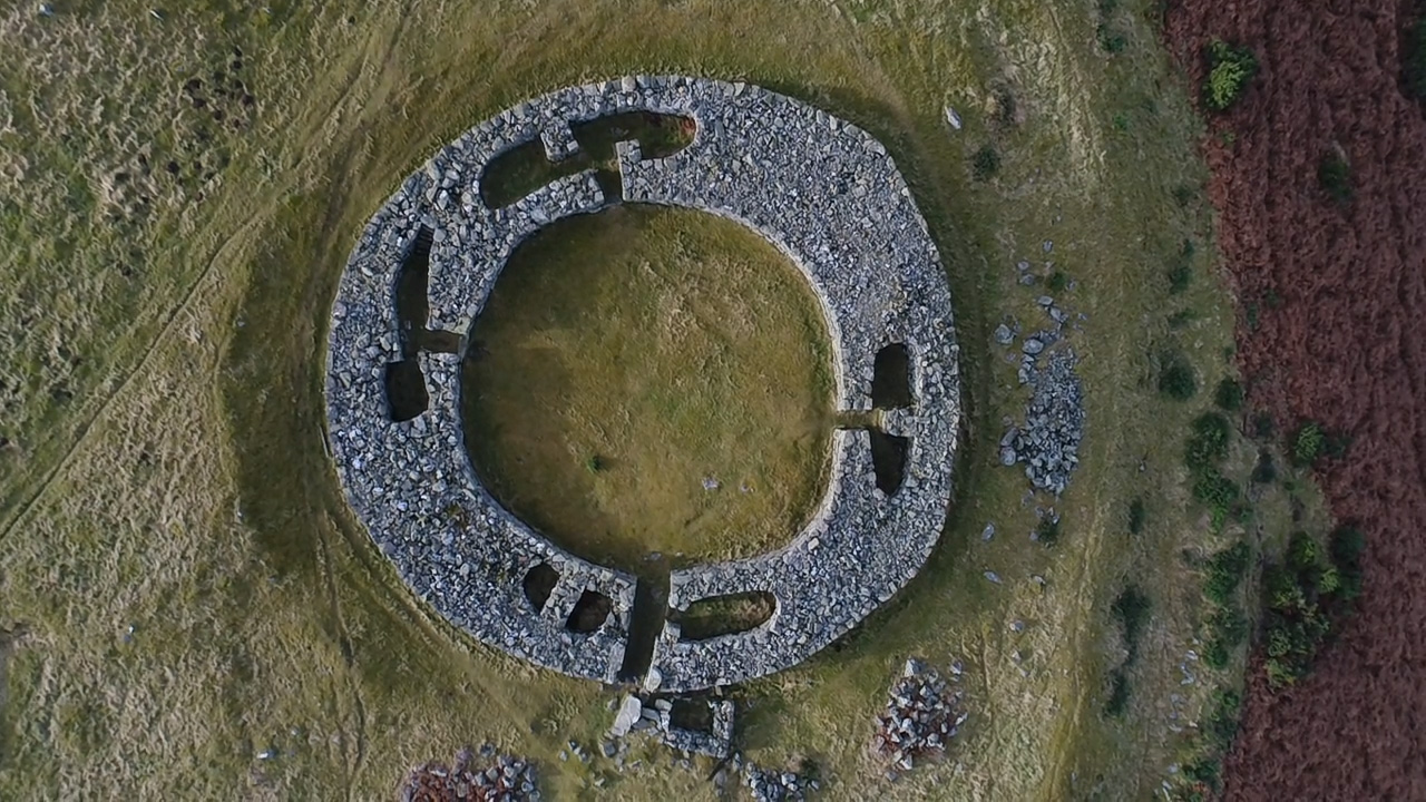 Looking directly down onto Edin's Hall Broch, showing the circular shape and small rooms enclosed within the thick stone walls.