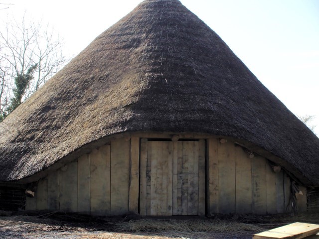 Rreplica roundhouse with conical thatched and wooden planking around the walls